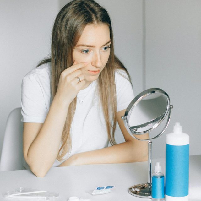 woman looking at the mirror pointing at herself